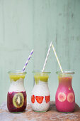 Various summery smoothies with sliced fruit