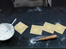 Preparing filled pasta: cut out ravioli with a pastry wheel