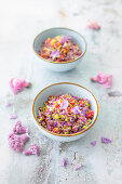 Low carb rice salad made from colorful cauliflower, peppers and edible flowers (vegan)