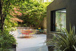 Colourful metal furniture in seating area on summery courtyard terrace