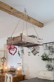 Christmas decorations on shelf suspended from ceiling in rustic kitchen