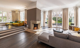 Spacious, elegant, split-level living room in shades of brown with corner fireplace