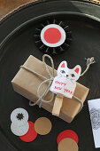 New Year's greetings on cat-shaped paper tag on gift