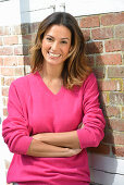 A young woman wearing a pink jumper