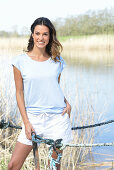 A young woman wearing a light-blue T-shirt and white shorts near river