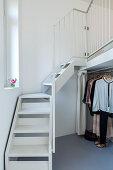 Clothes rail below staircase