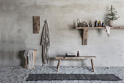 Bathroom utensils on wooden shelf, wooden bench, bathrobe and laundry basket