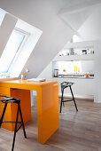 Orange, retro desk in open-plan attic apartment