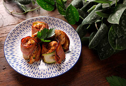 Chicken skewers with bacon and zucchini being prepared