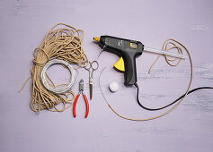 Craft utensils for making bunny decorations: cord, wire, hot glue gun and pompom