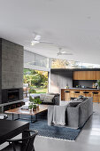 Modern open-plan living room in grey with open kitchen and garden access