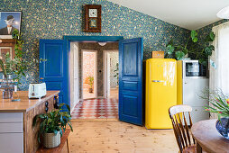 Blaue Doppeltür und gelber Retrokühlschrank in der Wohnküche