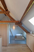 View into white, minimalist modern bathroom with wooden beams
