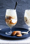 Glasses with banana pudding - sliced bananas, wafer cookies, vanilla pudding, whipped cream and caramel sauce