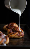 Zimtschnecke mit Zuckerguss beträufeln