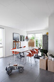 Rutschauto vorm offenen Esszimmer mit Designerstühlen in Orange