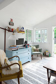 Hellblaue Kommode im hellen Wohnzimmer im Vintage-Stil
