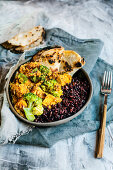 Vegan curry with tofu, black rice and naan (India)