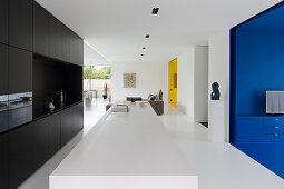 Modern kitchen in open-plan interior with brightly coloured alcoves