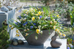 Gray bowl with wild tulips, grape hyacinths, ray anemones and primroses, Easter bunny and Easter eggs
