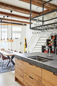 Kitchen island with integrated sink and dining table and staircase in background