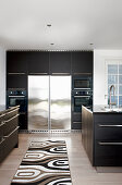 Black fitted cabinets in large modern kitchen