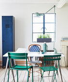 Dining table and various garden chairs with blue metal locker in background