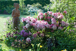 Schattiges Beet mit Rhododendron 'Silberwolke', Funkie, Hornveilchen, Zierlauch 'Ostara' und Akelei, Terracotta-Figur