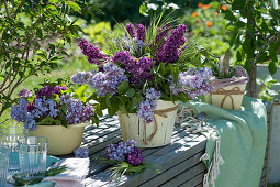 Light and dark mixed lilacs bouquet on bench in the garden