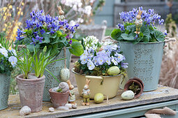 Easter decorations with fragrant violets, grape hyacinths, horned violets and star of milk, Easter eggs, Easter bunnies and empty snail shells as decoration
