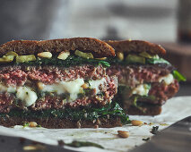 Burger with minced meat, mozzarella, spinach and pine nuts