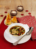 Clear mushroom broth with herb puff-pastry Christmas trees