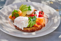 Bread topped with smoked salmon, avocado and poached eggs