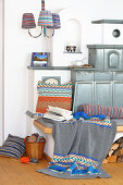 Knitted textiles with classic patterns around tiled stove