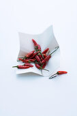 Top view of dried red hot chili peppers arranged in pots for sale on market