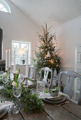 Festlich gedeckter Holztisch in Weiß, Grün und Grau zu Weihnachten
