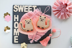 Cat-shaped biscuits on pink feathers made from string