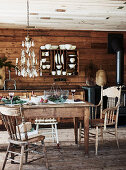 Rustic dining table in front of board wall with plate board