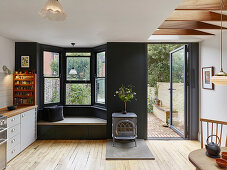 Classic kitchen-dining room with seat in bay window and door leading into garden