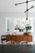 Retro sideboard below interior window in dining room