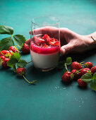 Vegan coconut panna cotta in a glass with strawberry groats