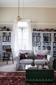Ländliches Wohnzimmer mit Holztruhe als Couchtisch und Bücherschränke