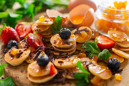 Mini-Pancakes mit Sirup, Beeren, Orangeat und Schokolade