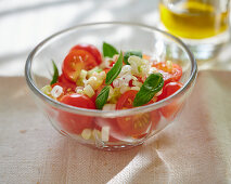A tomato salad with spring onions and basil