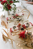 Table set for Christmas meal with red paper star and vase of amaryllis