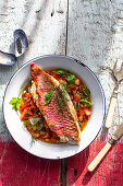 Fried red mullet fillet on a tomato and onion salad with fresh herbs