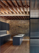 Modern monochrome kitchen with wood-beamed ceiling in restored brick house