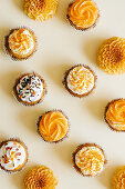 Cupcakes with vanilla cream cheese frosting decorated with sugar sprinkles in autumn style