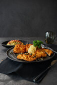Wiener Schnitzel with caper butter and bacon and potato salad