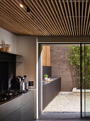 Modern kitchen counter continuing onto courtyard terrace